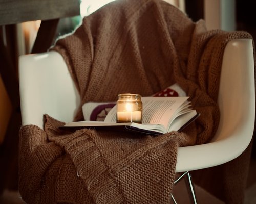 Cozy evening reading setup with a warm lamp light illuminating a book